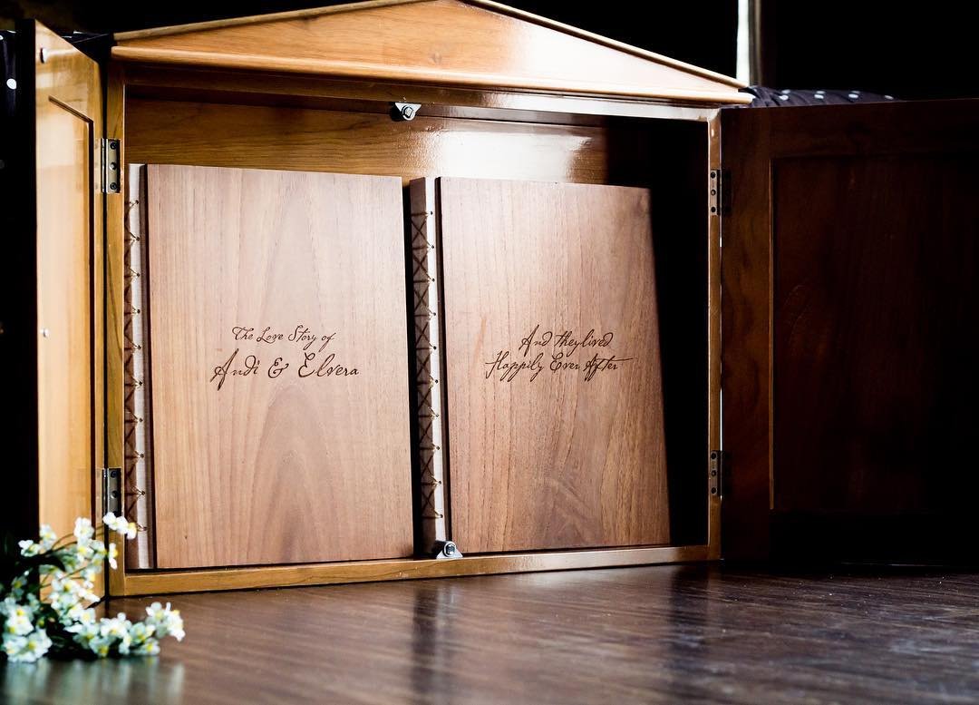 Two engraved wooden photobook boxes in a display cabinet
