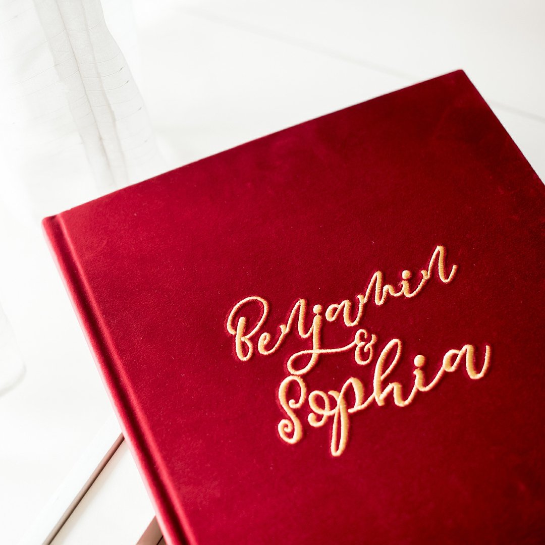 Red velvet photobook cover with gold calligraphy names