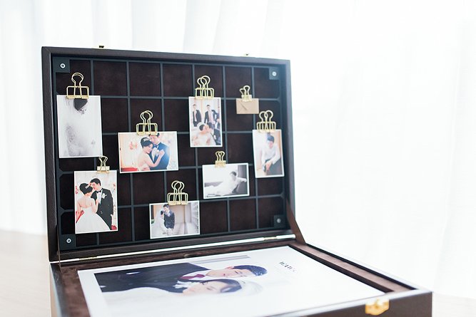 Open keepsake box with clipped photo prints inside the lid